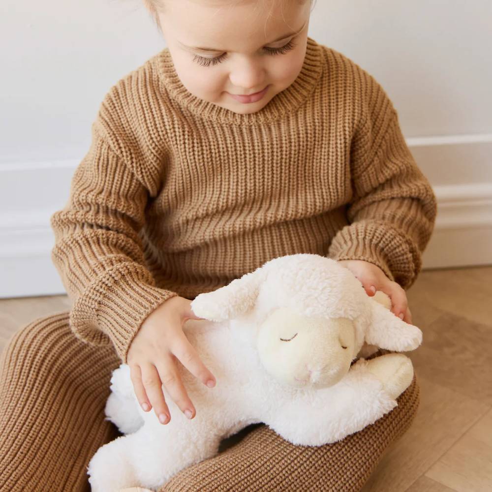 baby holding cream Jamie Kay lamb soft toy.
