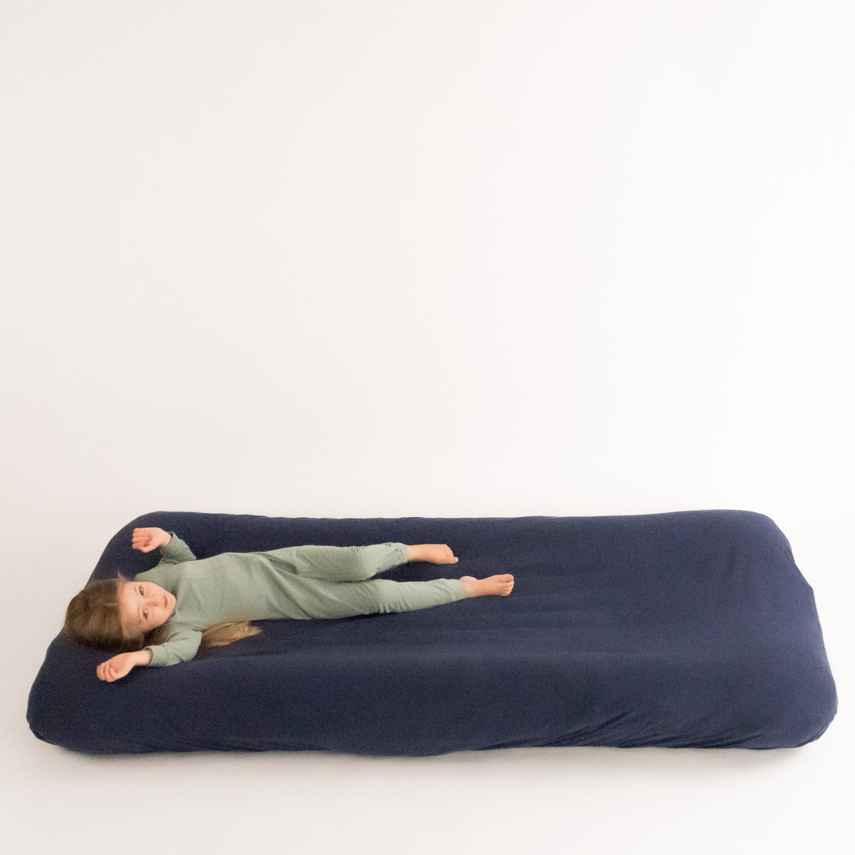 Child lying on inflatable travel bed. 
