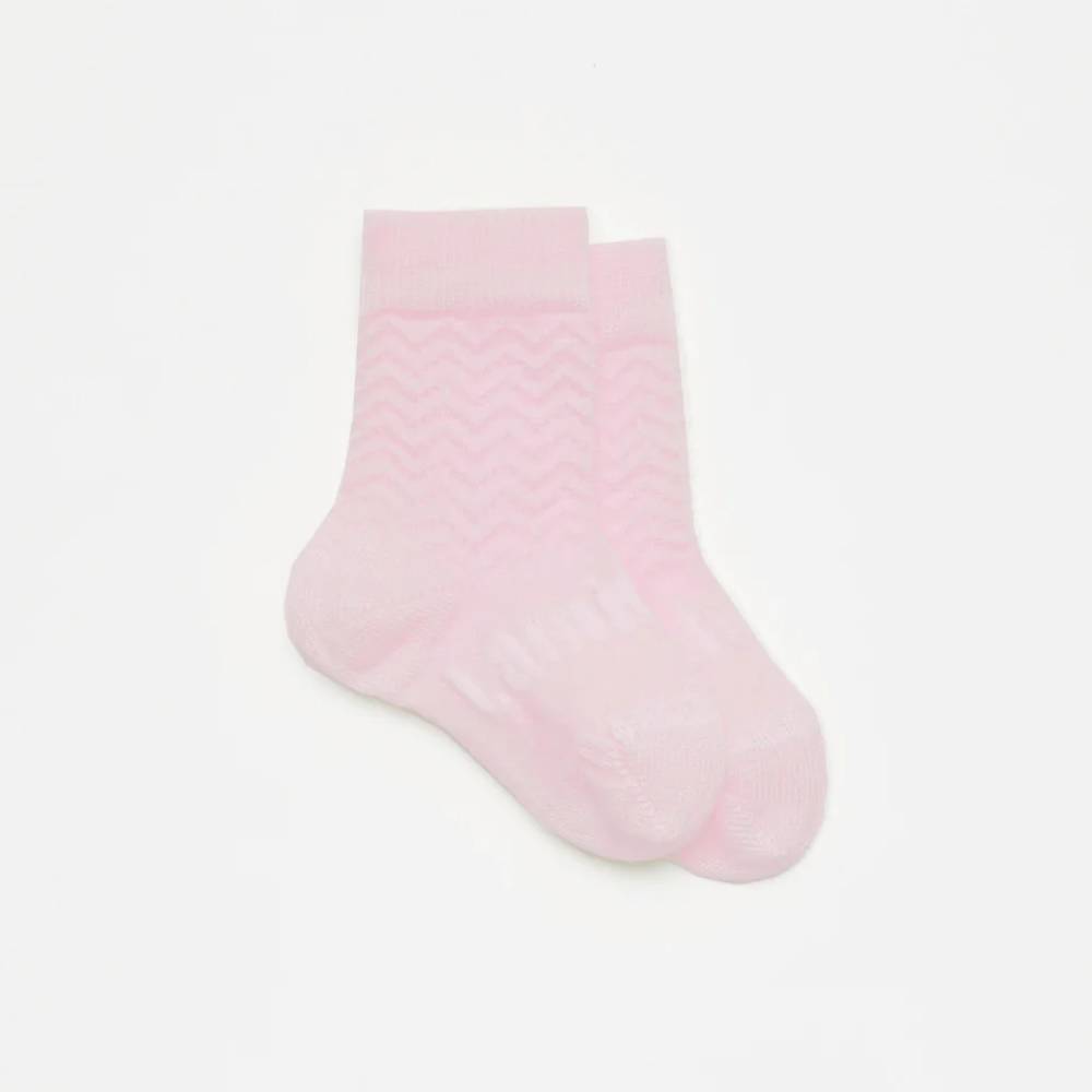 Pink merino crew socks on a white background