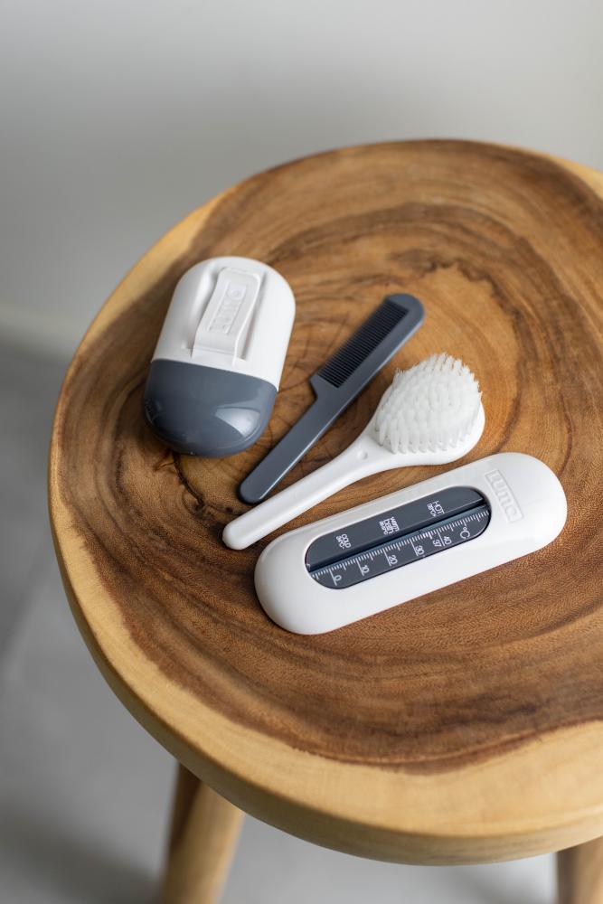White LUMA Brush and Comb Set next to a Baby Manicure set and bath thermometer. 