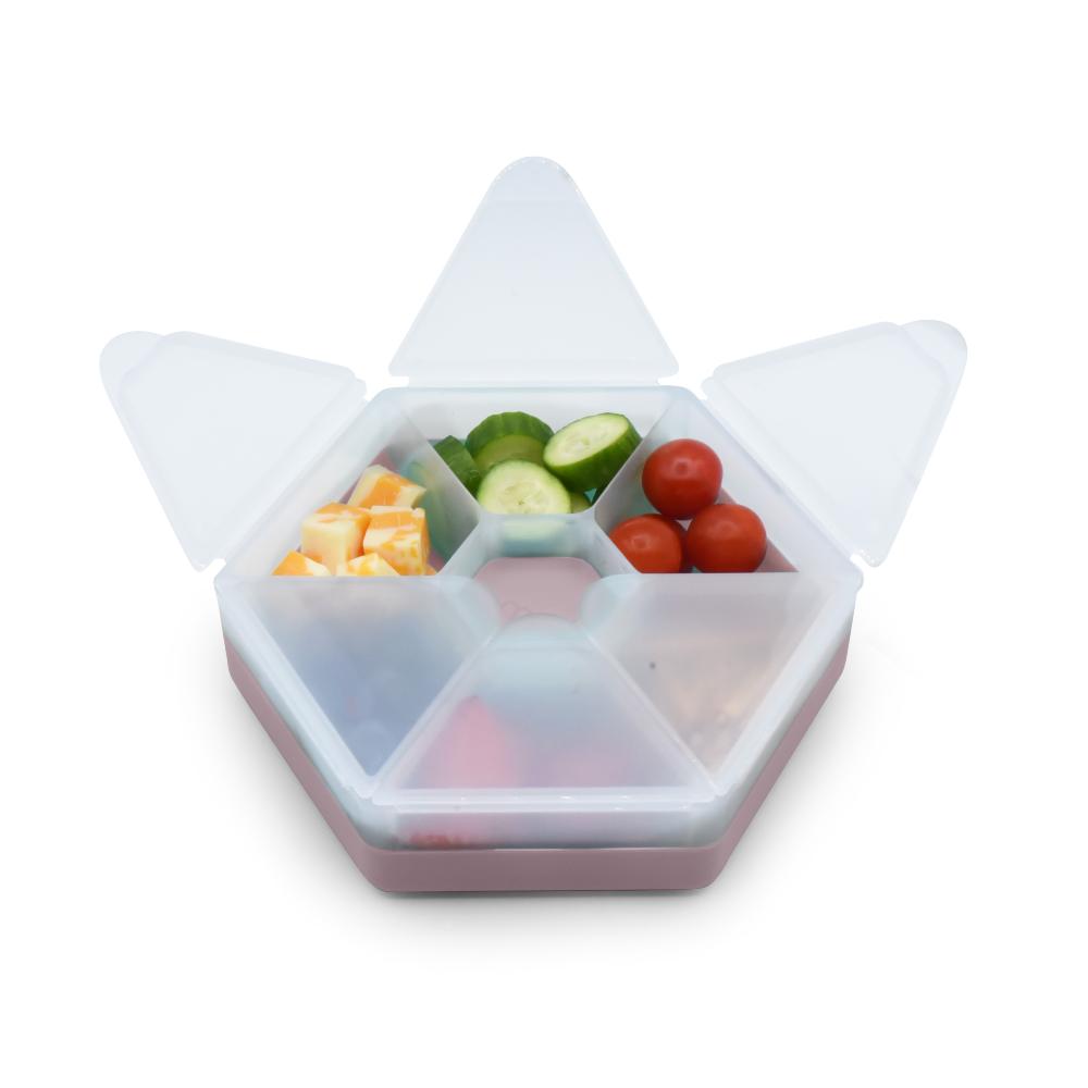 Hexagonal food container with compartments filled with fruits and vegetables on a white background