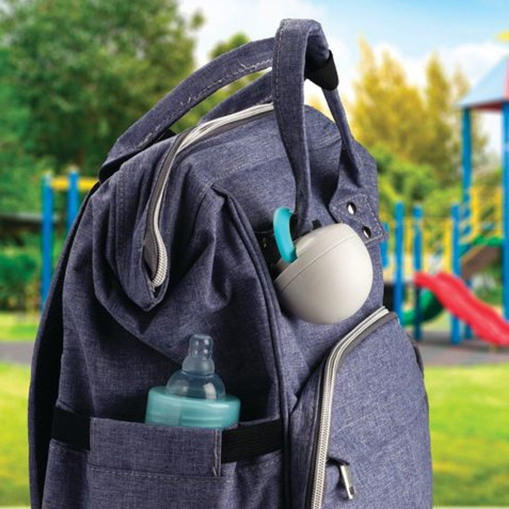Blue backpack with baby bottle and accessories in a park setting