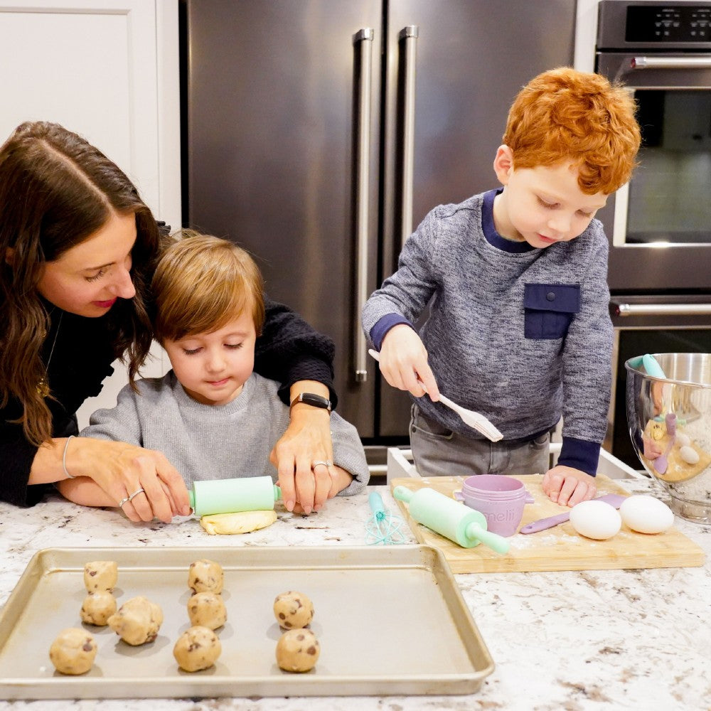 Family of three in a kitchen baking cookies with the Melii mini baking tools set