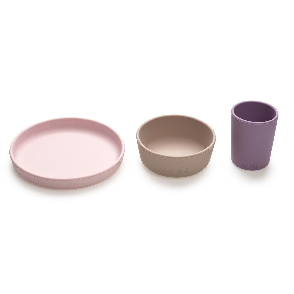 Set of three kids food dishes including a plate, bowl, and cup on a white background