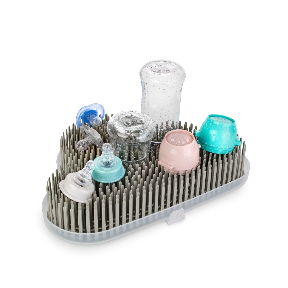Dishwasher rack with baby bottles and accessories on a white background