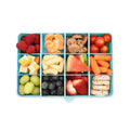 Assorted healthy snacks in a compartmentalized container on a white background