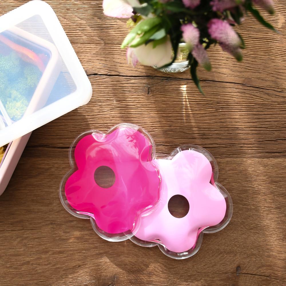 Pink flower-shaped gel packs on a wooden surface with a blurred background