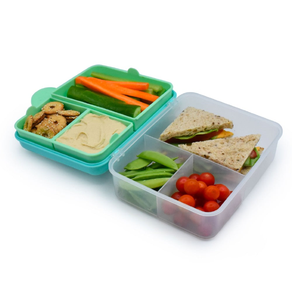 Bento box with compartments containing snacks and vegetables on a white background