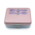 Pink lunch box with cutlery set on a white background