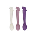 Three silicone spoons in white, pink, and purple on a white background