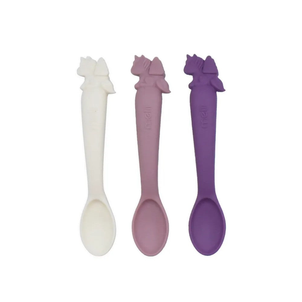 Three silicone spoons in white, pink, and purple on a white background