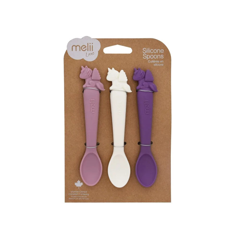 Three silicone spoons in pink, white, and purple packaging with 'mellii' branding on a beige background.