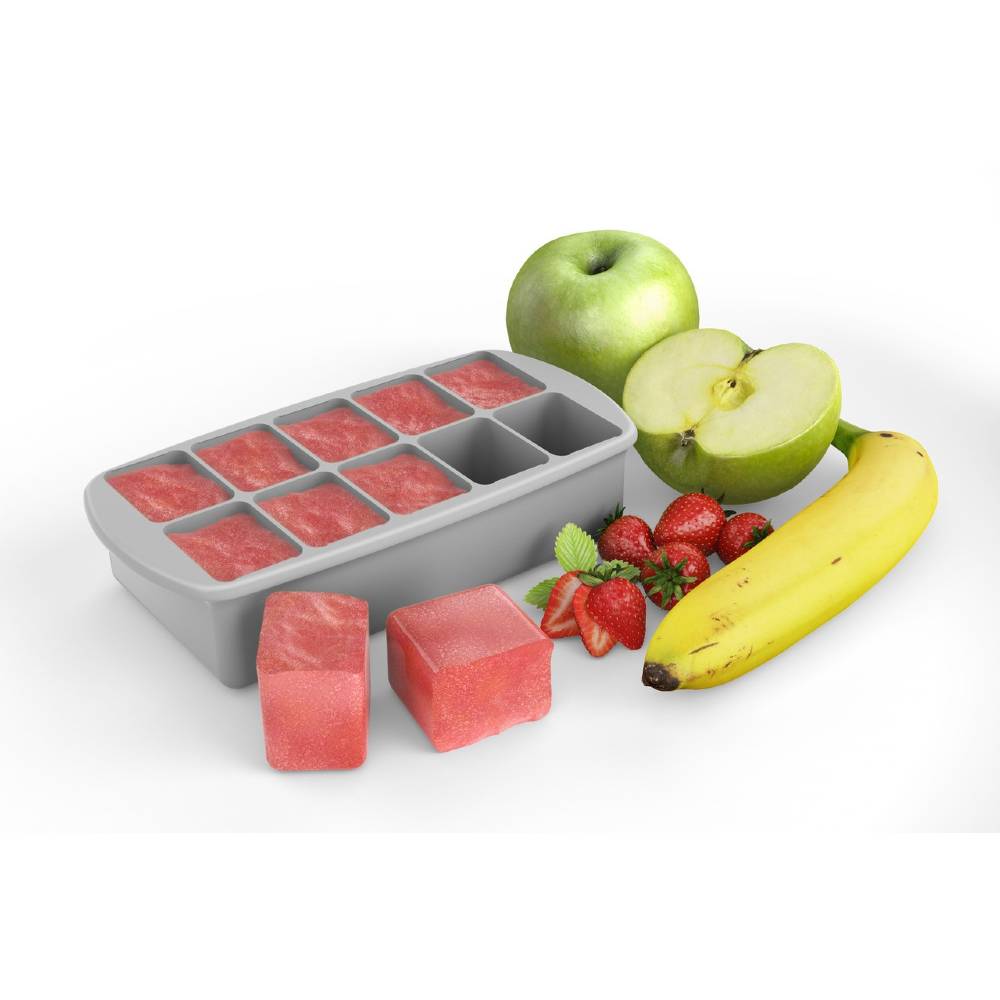 Gray silicone baby food freezer tray with a white container on a white next to fruits on a white background