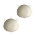 Two beige unicorn shaped silicone baby suction bowls with cat face designs on a white background