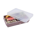 Pink bento box with compartments containing food on a white background