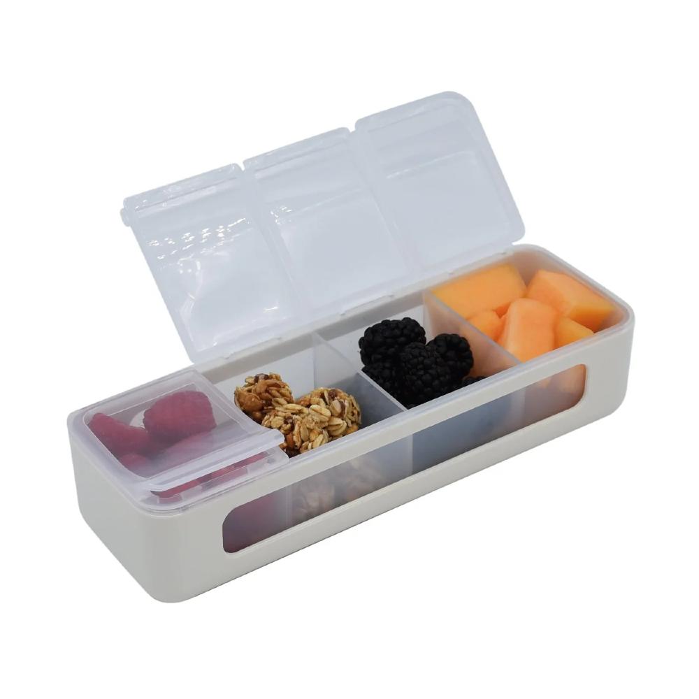 Transparent snack container with compartments filled with various snacks on a white background