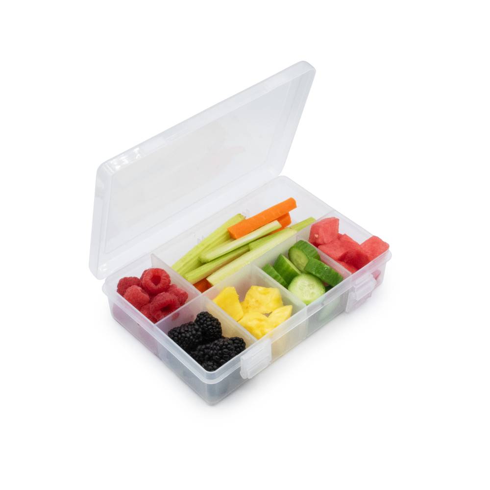 Transparent snack container with compartments filled with various fruits and vegetables on a white background