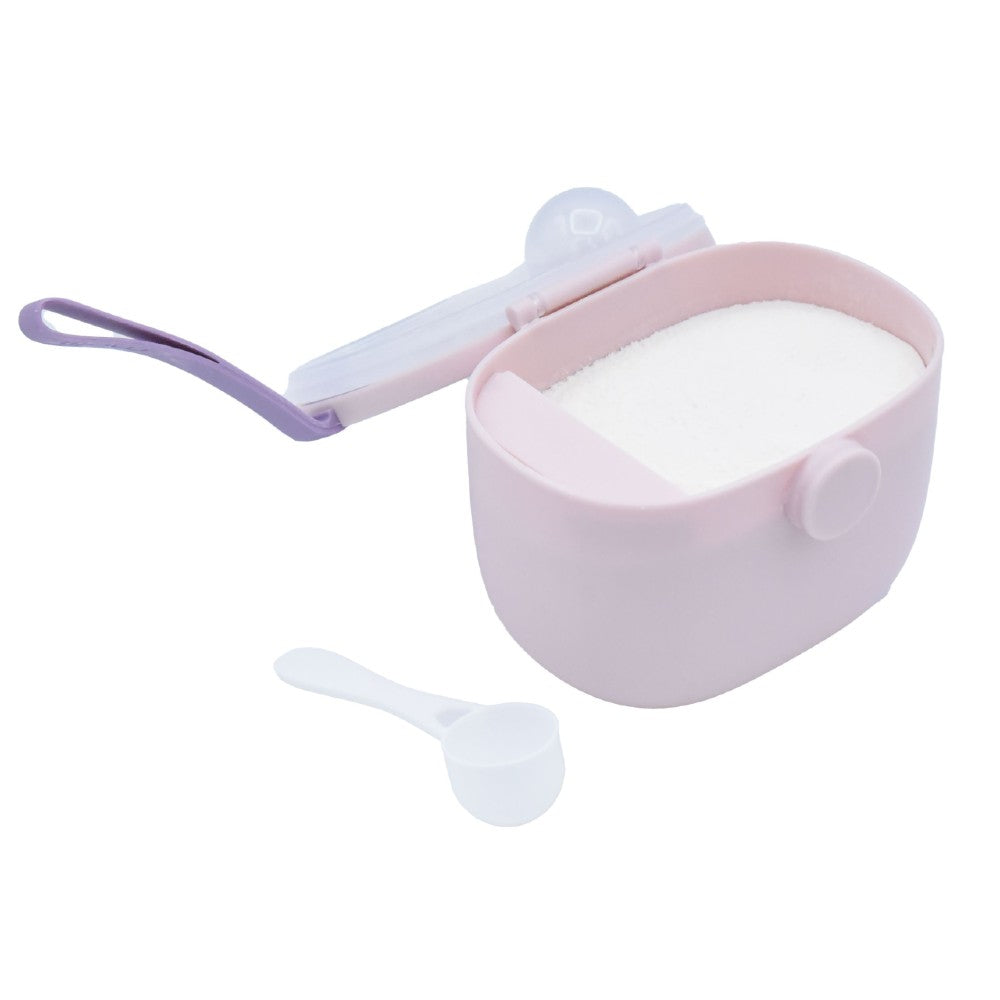 Pink baby formula powder container with a white spoon on a white background