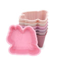 Stack of pink silicone baking molds on a white background