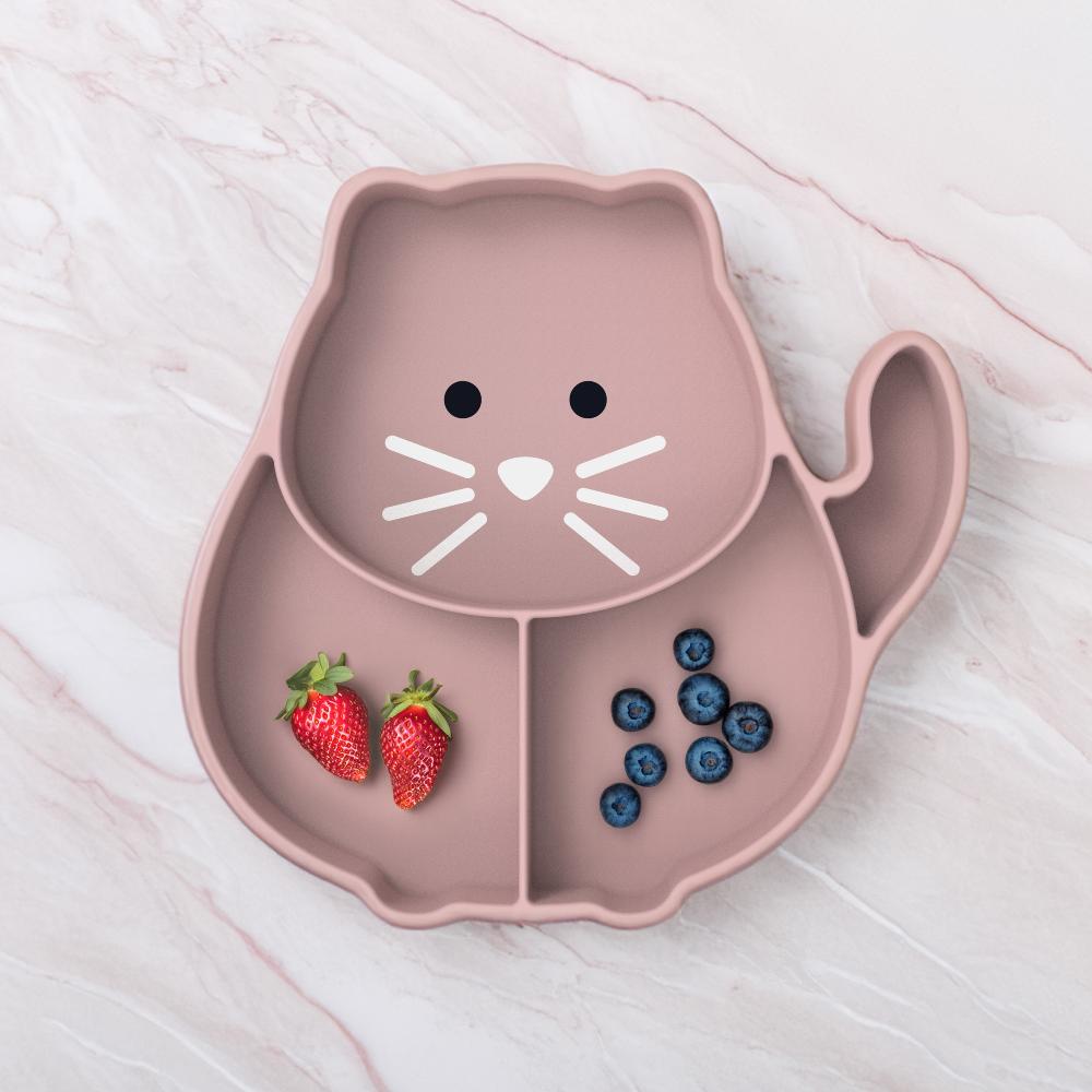 Pink cat-shaped plate with strawberries and blueberries on a light wooden surface