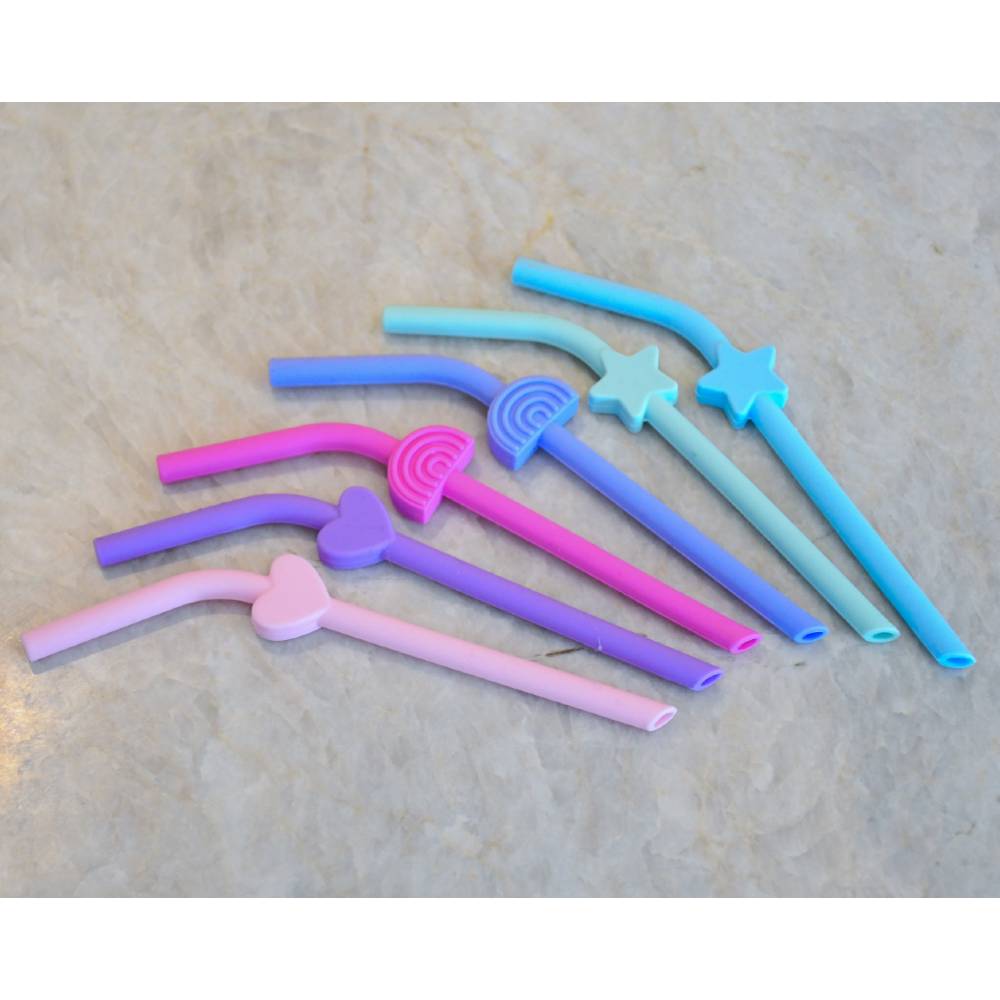Set of colorful silicone straws on a beige surface