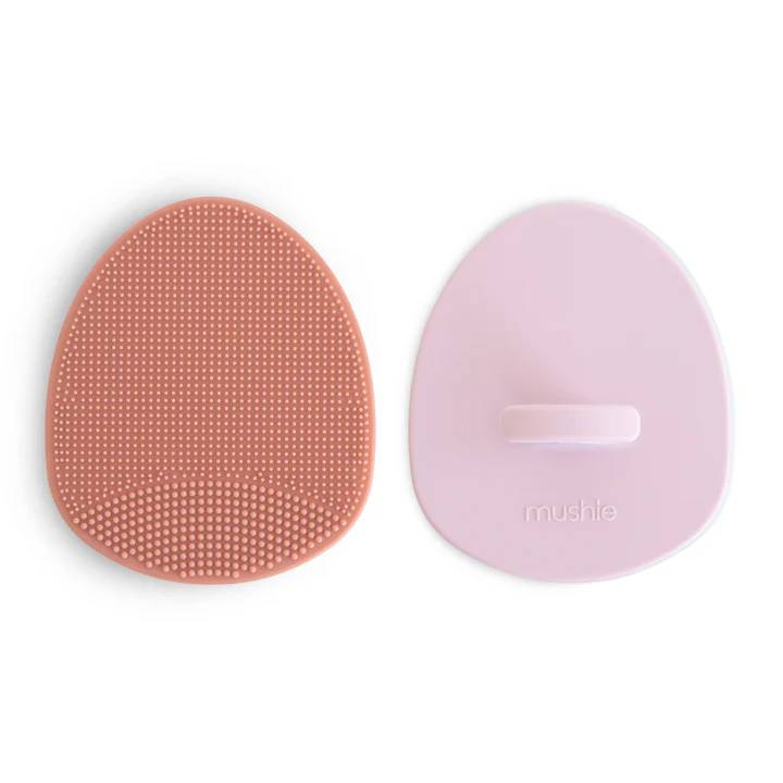 Two silicone brushes, one pink and one purple, on a white background.
