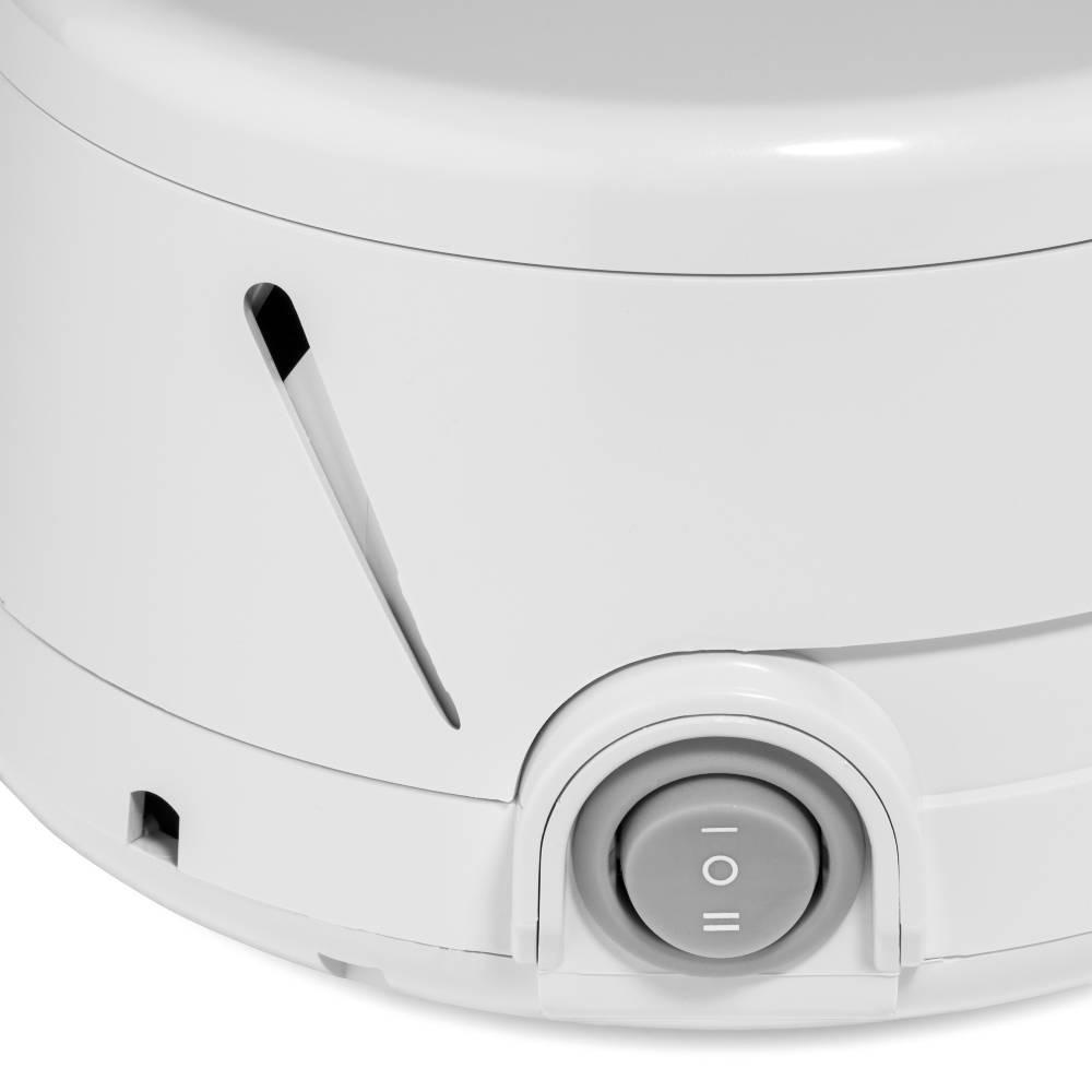 Close-up of a Dohm white noise machine with a power button on a light gray background