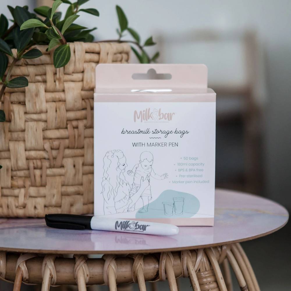 Milk bar breastmilk storage bags packaging with marker pen on a table with plants in the background