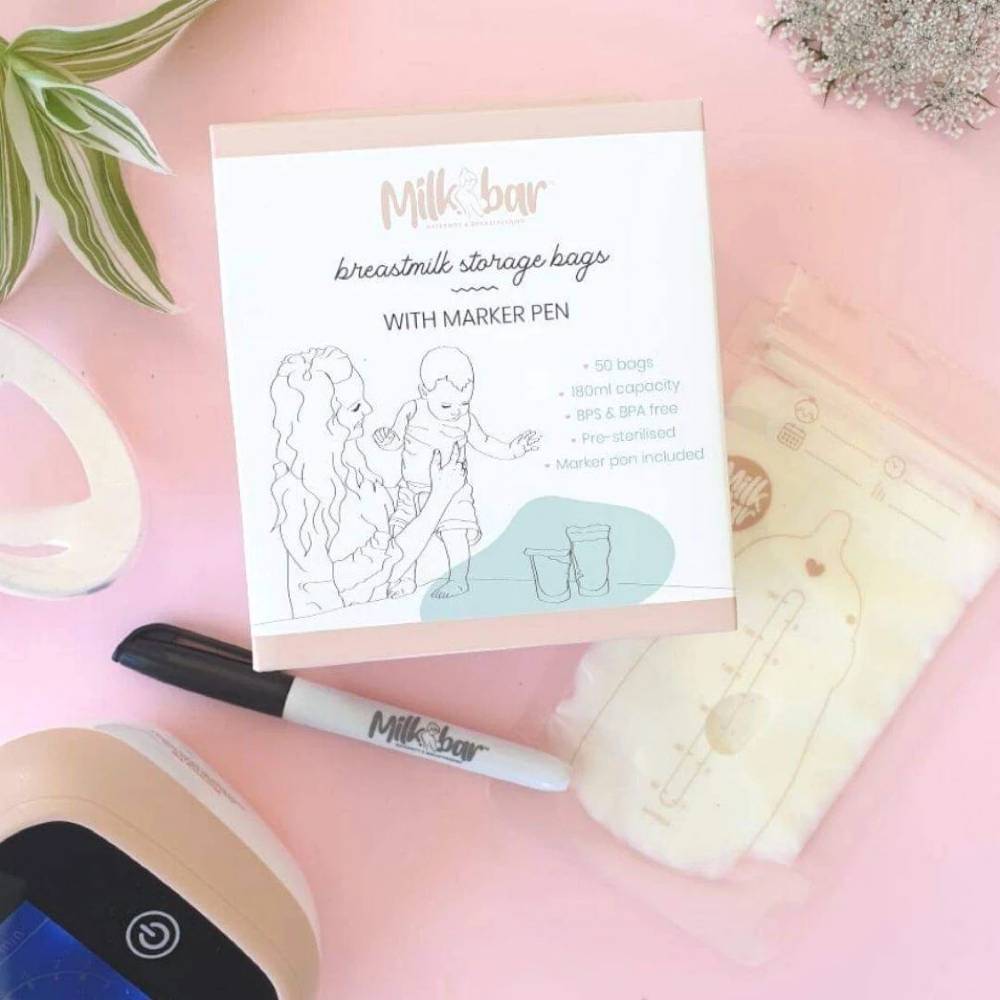 Milk bar breastmilk storage bags with a marker pen on a pink surface