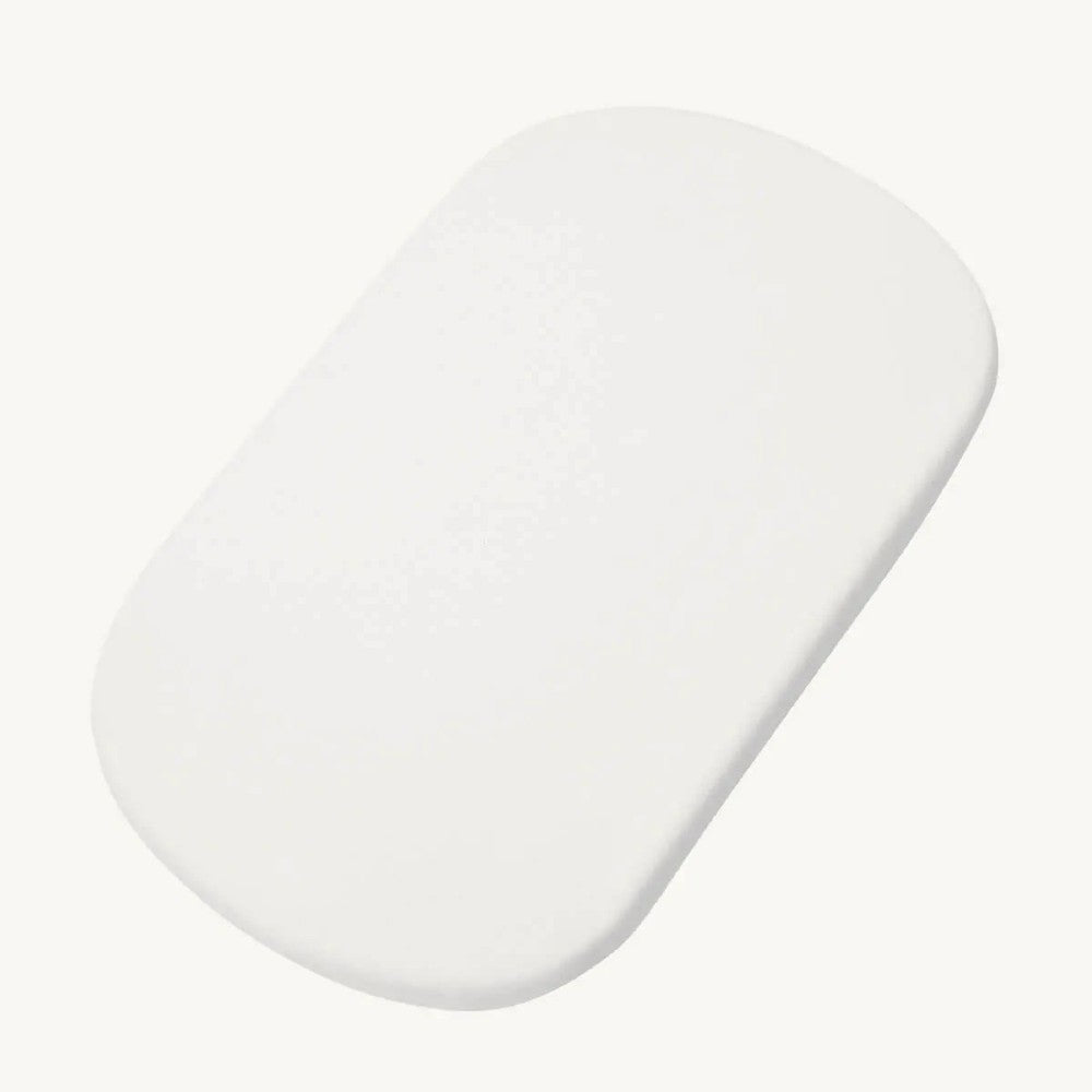 A white, oval-shaped mattress with rounded corners, shown on a solid off-white background.