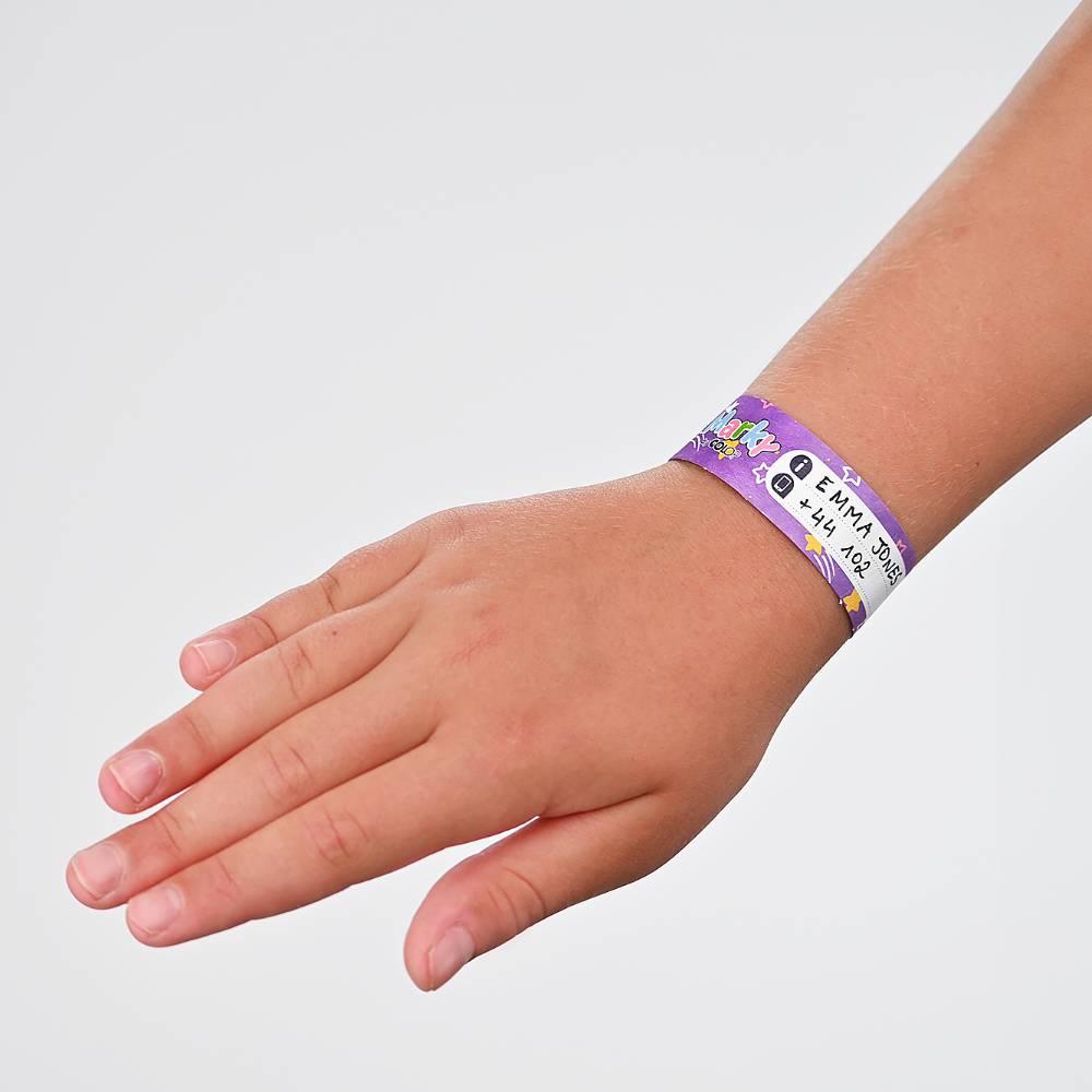 Child's hand wearing a purple wristband with text and graphics on a light gray background