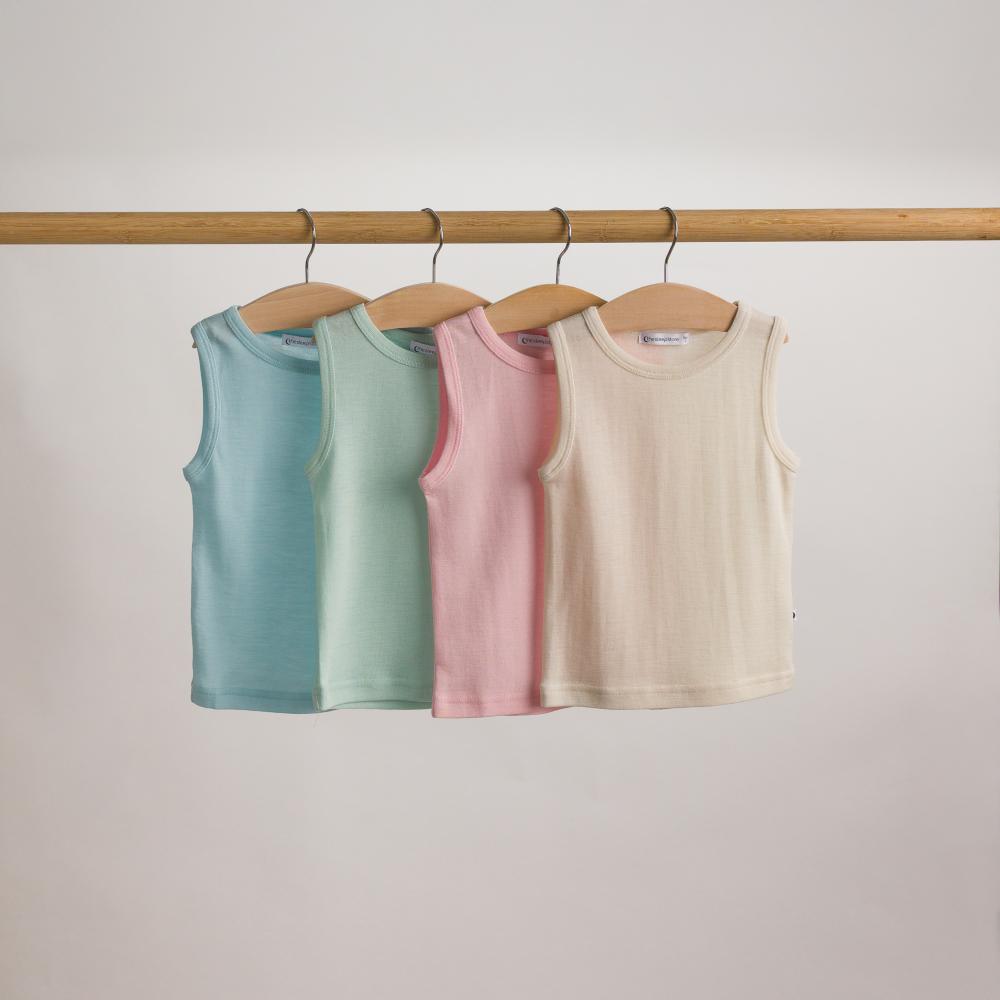 Four deluxe merino rib singlets in pastel colors hanging on a rack against a plain background