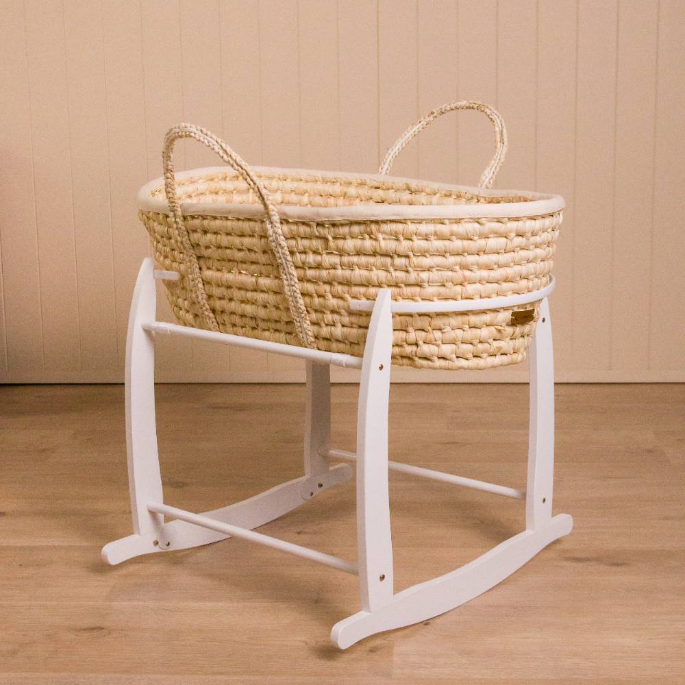 A moses basket rocking stand on a white background