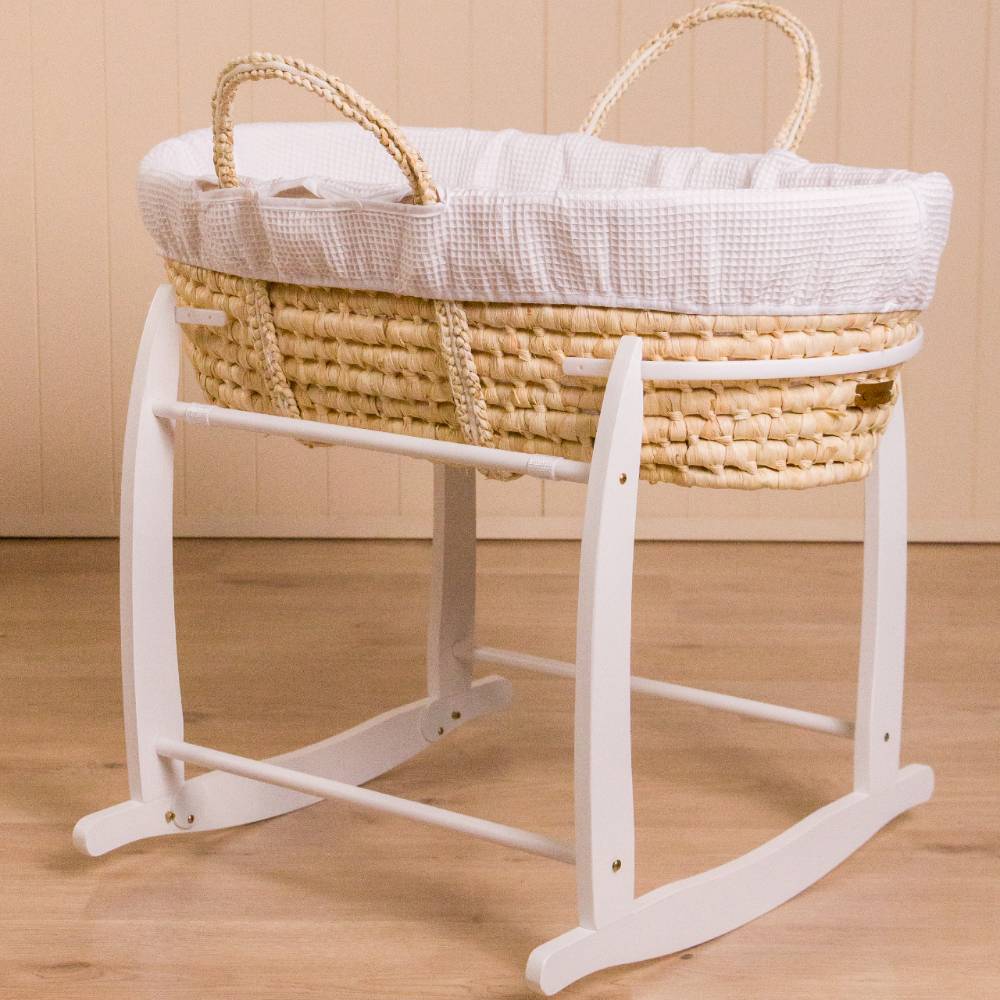 Wicker Moses basket on white wooden rocking stand