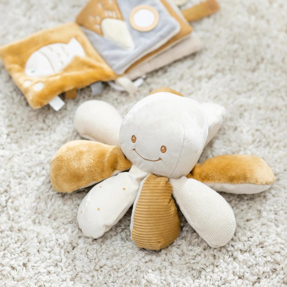 Plush Octopus toy with a smiling face on a textured surface