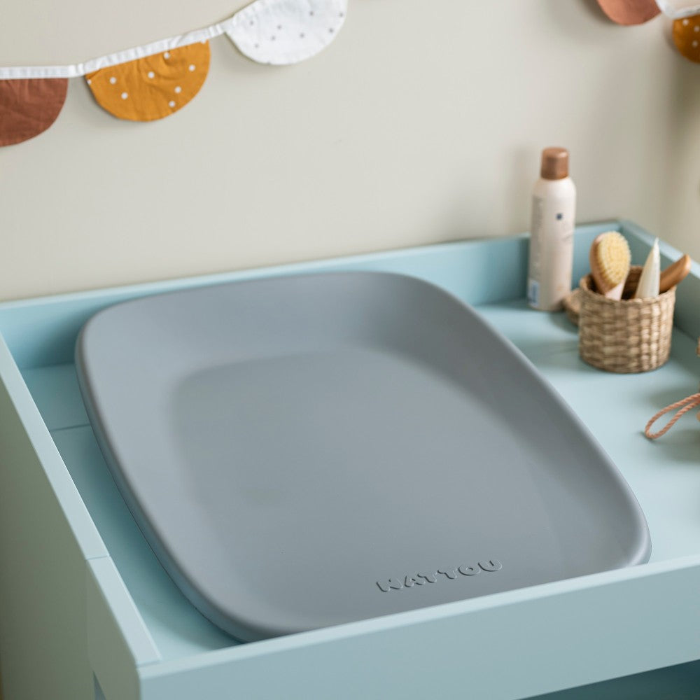 Gray baby change mat on a light blue tray with 'NATTOU' branding, set against a neutral wall.