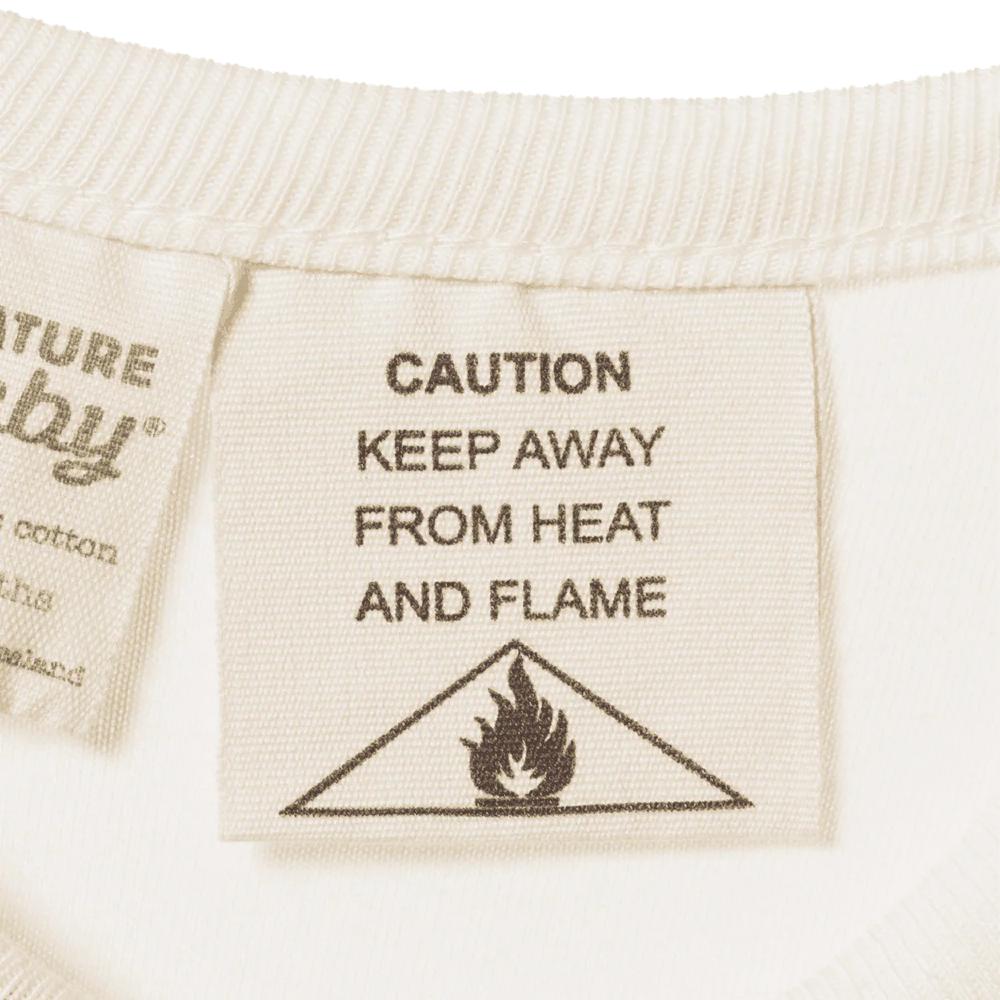 Textile label with 'Caution: Keep Away from Heat and Flame' warning on a white background