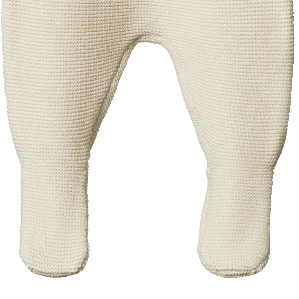 Close-up of cream-colored knitted baby footed pants on a white background