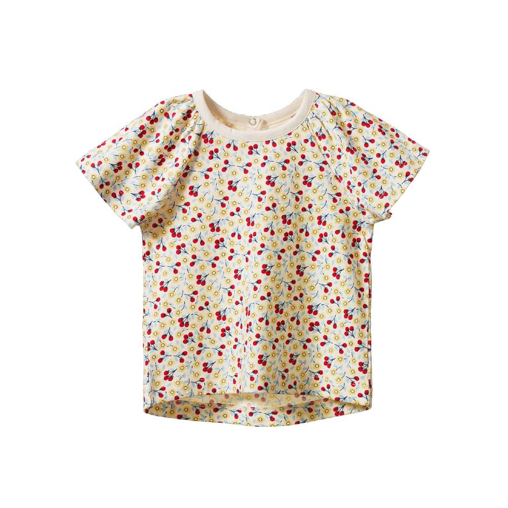 A short-sleeve baby top with a dense floral pattern on a cream background, featuring a ruffled shoulder and snap closures at the collar.