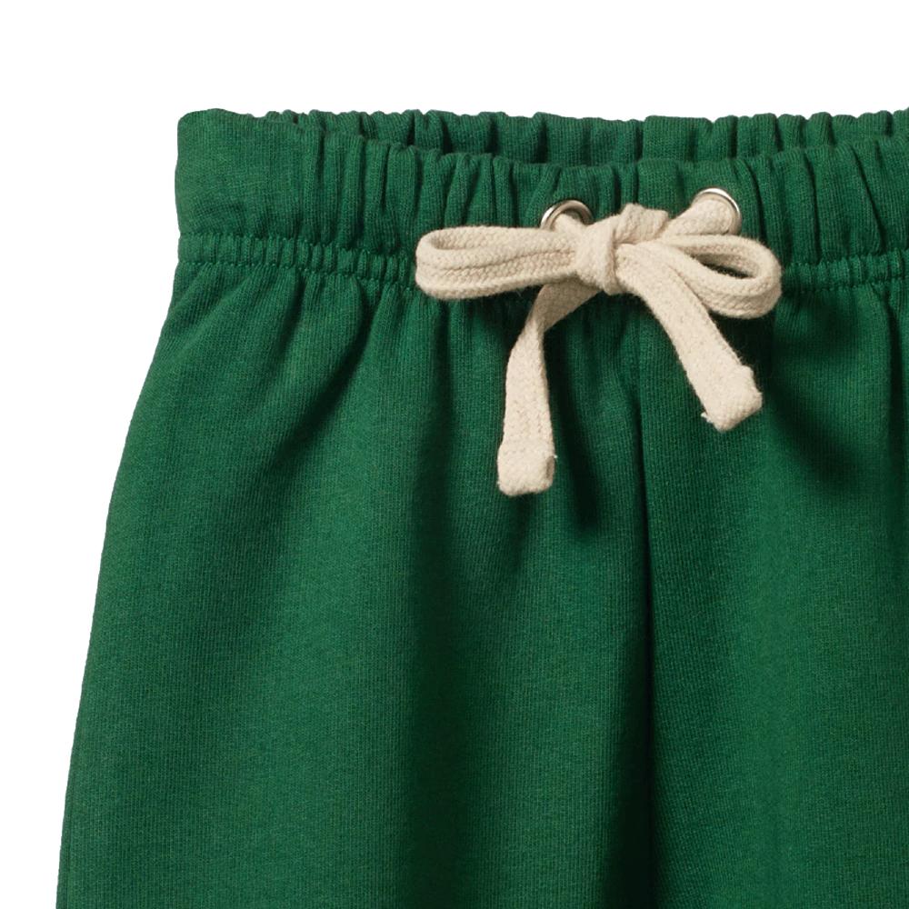 Close up of the waistband of cotton Green track pants with a beige drawstring on a white background