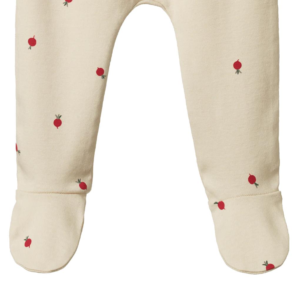 close-up of cream baby footed pants with red radish patterns on a white background