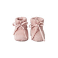 Pair of pink knitted baby booties with knitted ribbons on a white background