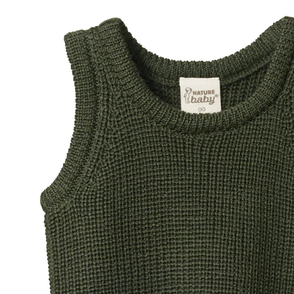 Close-up of green merino wool knitted baby vest with a visible Nature Baby brand label on a white background