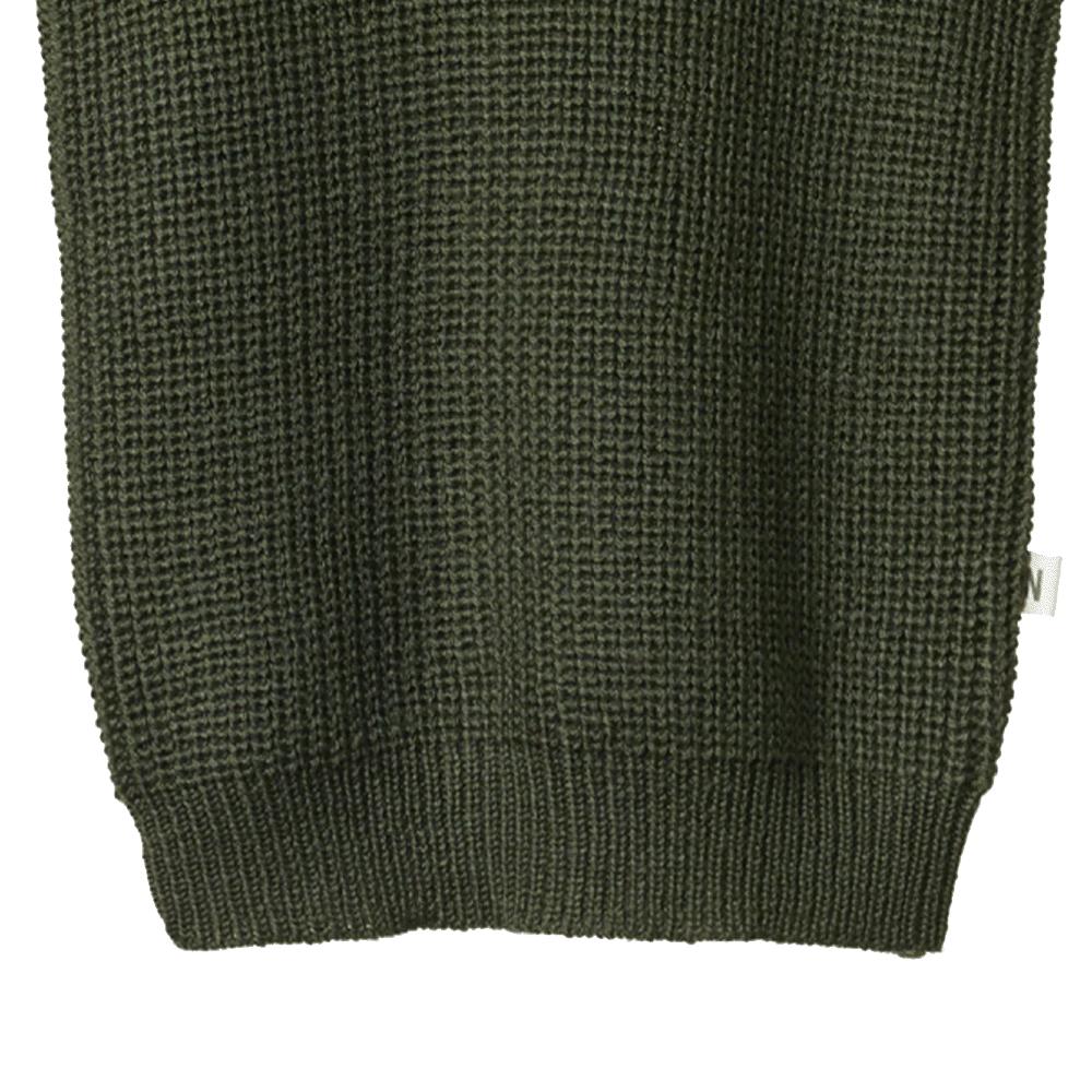 Close-up of a dark green knitted merino wool sweater on a white background