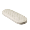 Cream coloured quilted moses basket mattress on a white background