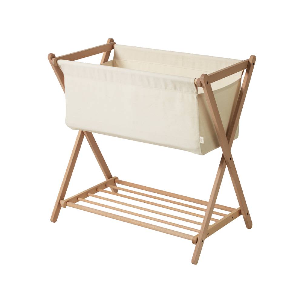 Wooden baby bassinet with crossed ends with beige fabric cover on a white background