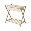 Wooden folding table with slats and a beige/cream fabric top on a white background 