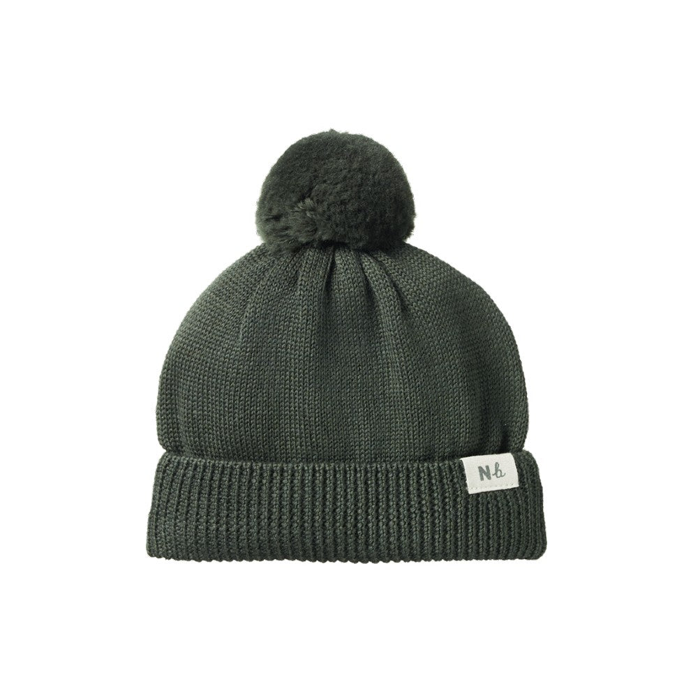 Forest Green knit beanie with pom-pom and NB linen tag on a white background