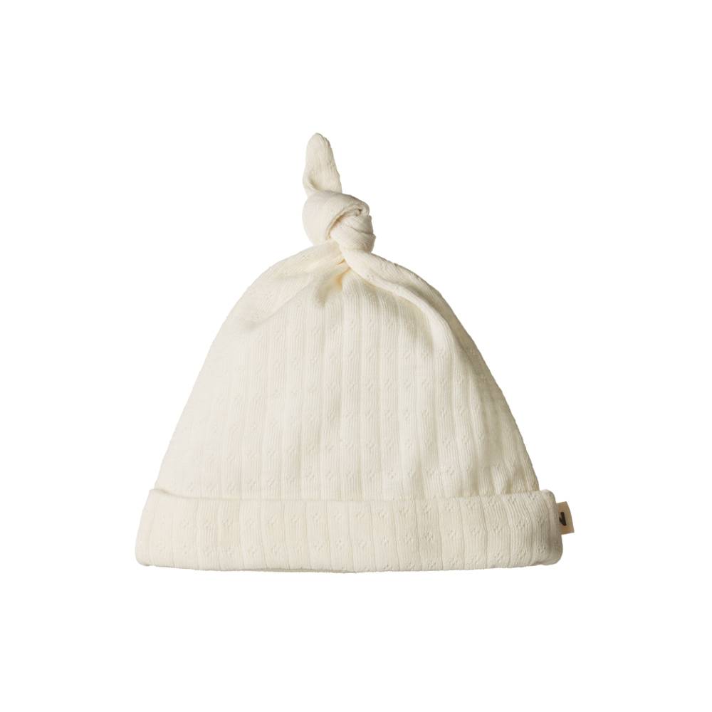 Cream merino pointelle knit baby hat with a knot on a white background