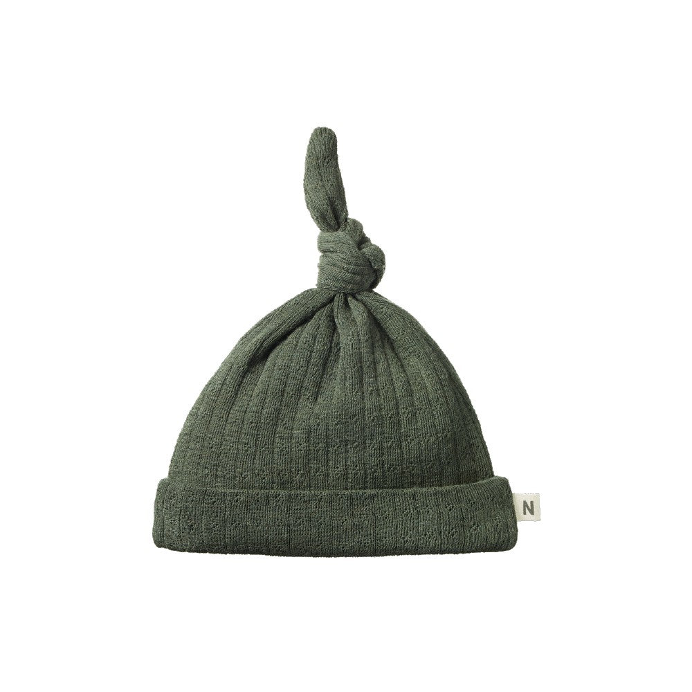 Green knotted baby hat in a merino pointelle fabric on a white background